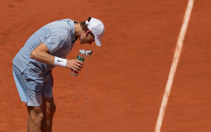 Jannik Sinner pours water on himself in his match against Juan Manuel Cerundolo at the 2026 French Open.